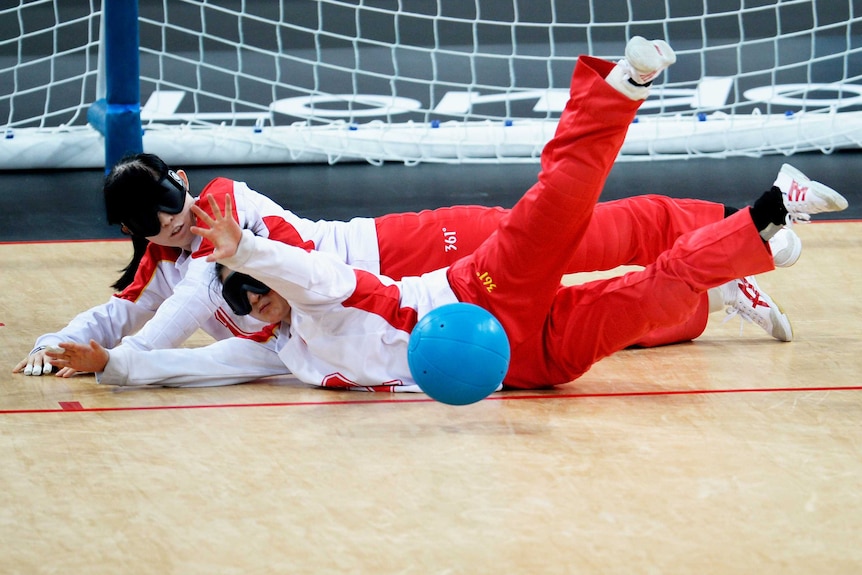 Wang Ruixie, Chen Fengqing of China block ball against Japan in goalball at the London Paralympics.
