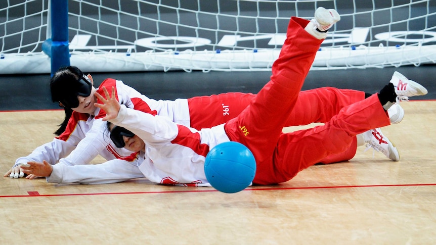 Wang Ruixie, Chen Fengqing of China block ball against Japan in goalball at the London Paralympics.