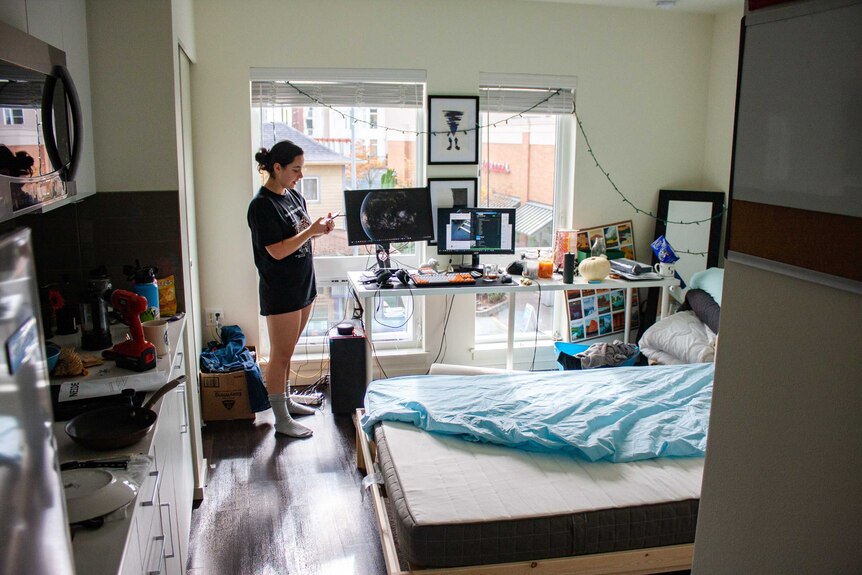 Woman standing in messy bedroom