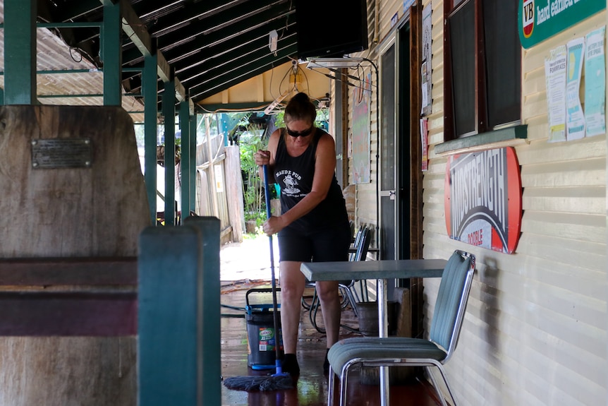 Woman mopping the deck of a pub