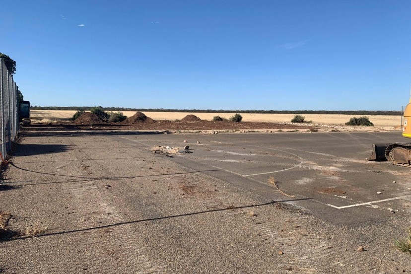 A court in poor condition being worked on with machinery