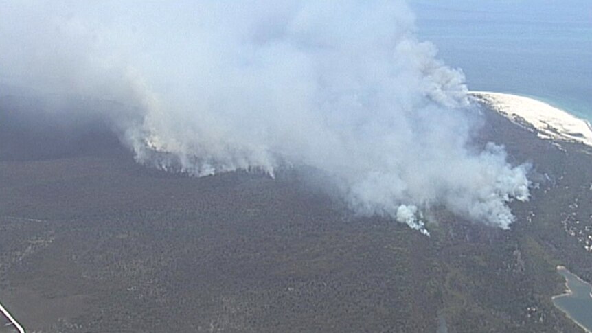 Large of plumes of smoke fill the sky from fires burning in bushland on Moreton Island.