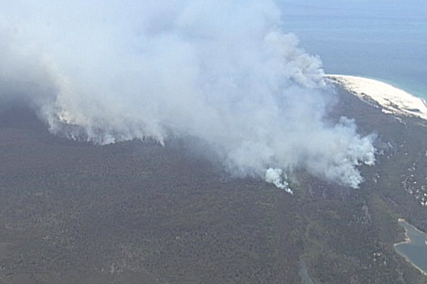 Large of plumes of smoke fill the sky from fires burning in bushland on Moreton Island.