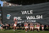 Crows and Power players run through the same banner before play at Adelaide Oval on July 19, 2015.