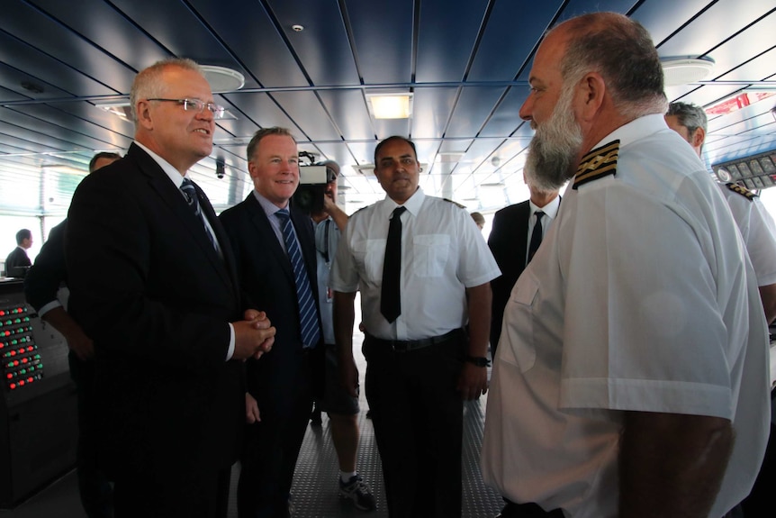 Prime Minister Scott Morrison (L) speaks to the captain of the new Toll ship (R) in Burnie.