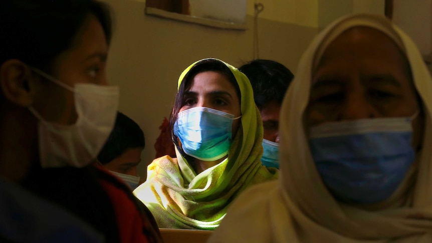 A Christian woman wears a face mask to protect against coronavirus during a prayer service