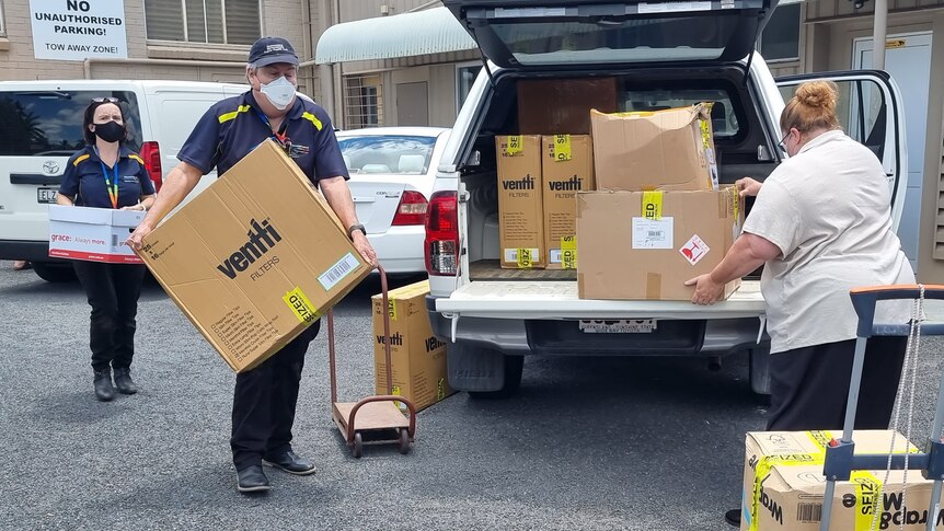 Health unit officers load a van with boxes allegedly containing illegal tobacco products