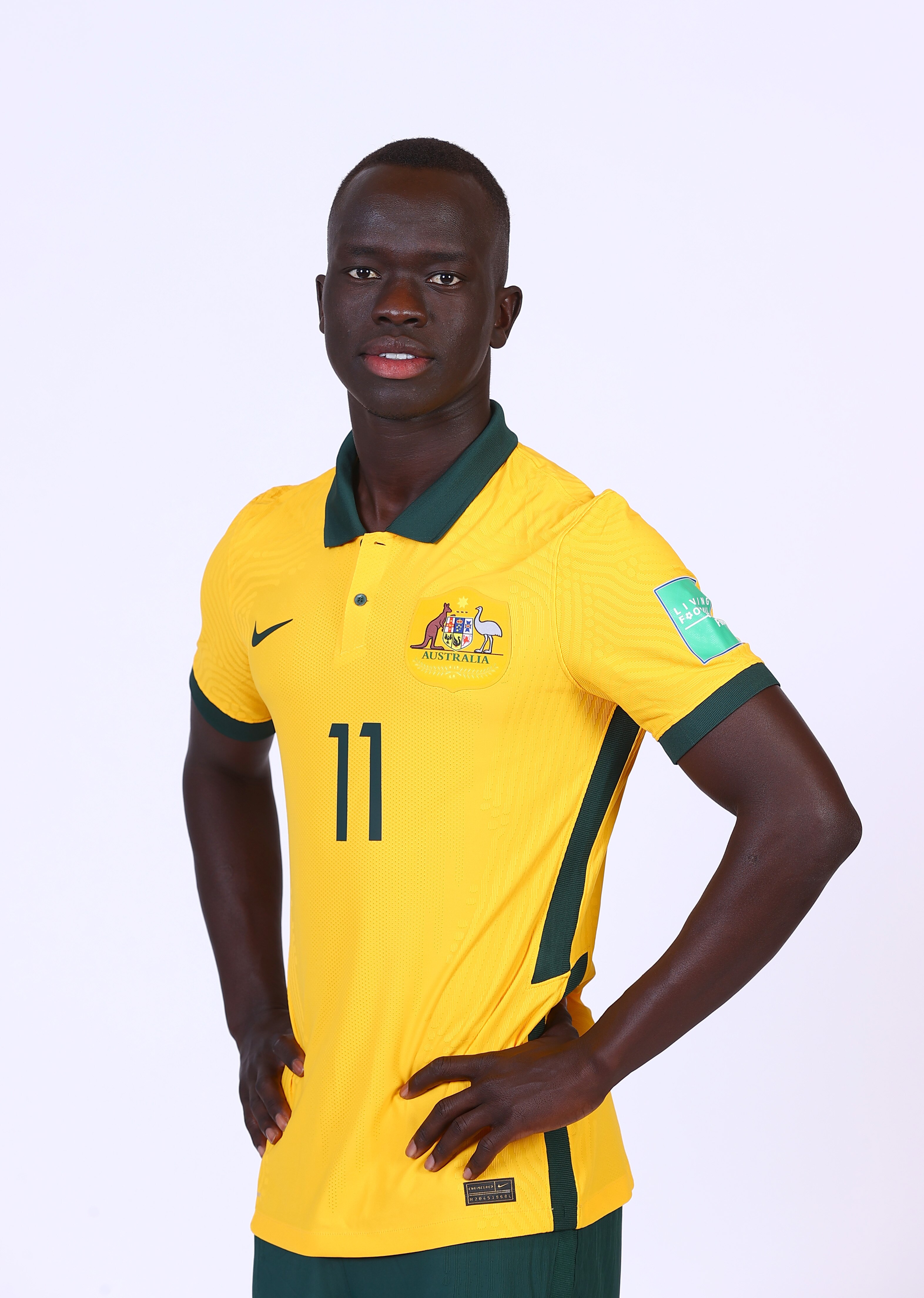 Australian socceroos player with hands on hips wearing yellow and green team jersey