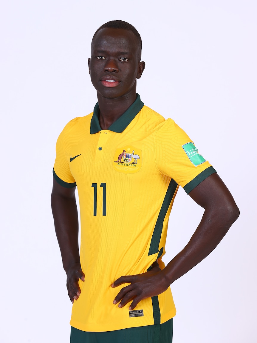 Australian socceroos player with hands on hips wearing yellow and green team jersey