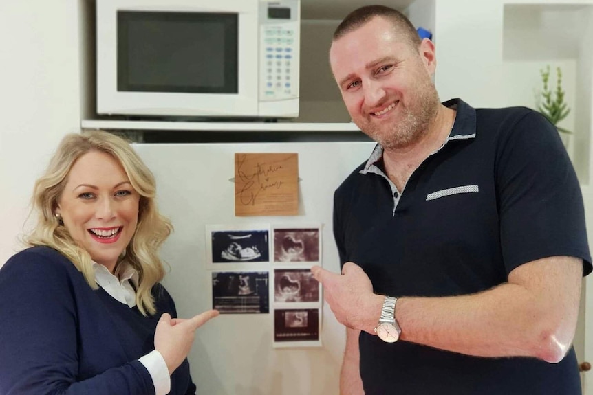 Katherine Gobbi and her husband Graeme Anstey point to an ultrasound of their unborn child.