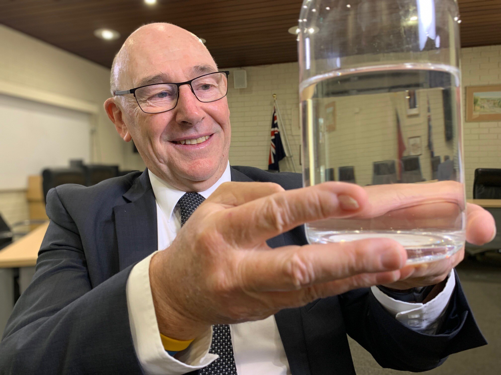 A man holds a glass of water.