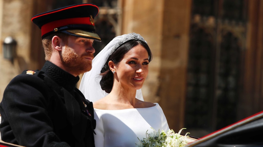 Britain's Prince Harry, left, and Meghan Markle leave in a carriage after their wedding ceremony.