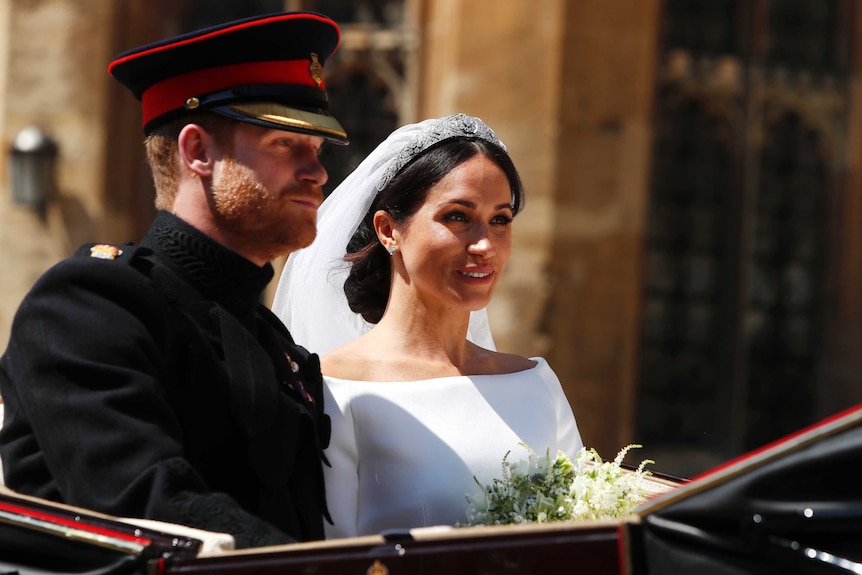 Britain's Prince Harry, left, and Meghan Markle leave in a carriage after their wedding ceremony.