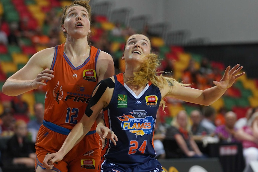 Nadeen Payne of the Townsville Fire and Anneli Maley of the Sydney Uni Flames contest a rebound in the WNBL.