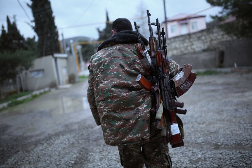 A soldier of the self-defence army of Nagorno-Karabakh carries weapons.