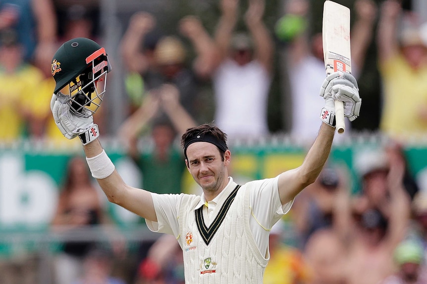 Kurtis Patterson raises his bat and helmet in celebration after scoring his maiden Test century
