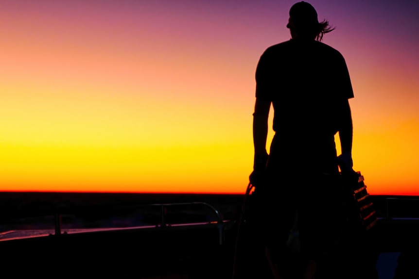 A sunset silhouette of a crayfisher