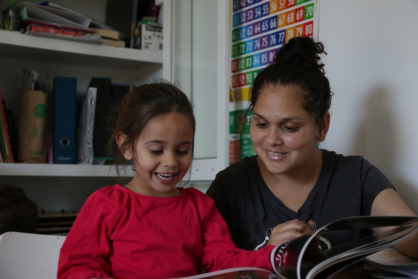 Five-year-old Amity reading a picture book with her mother, Larteasha Griffen