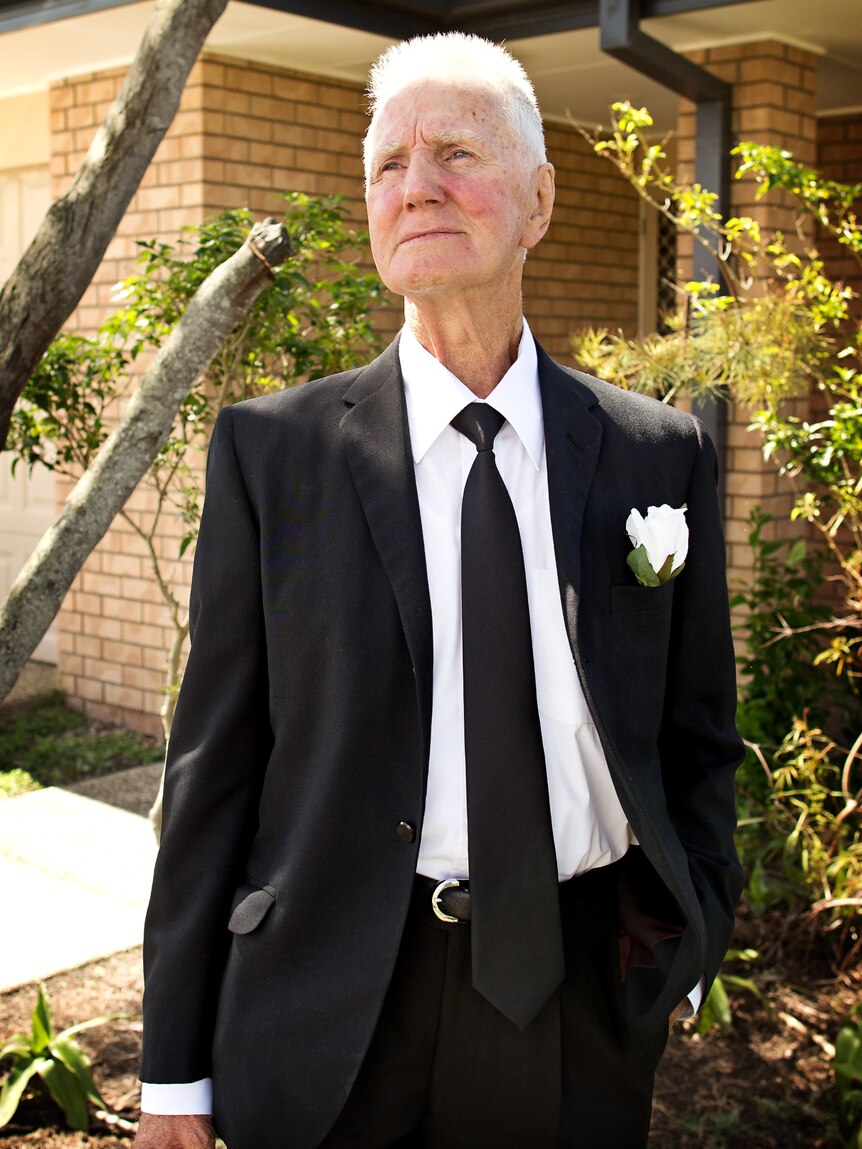 Keith Briese stands in a black suit. 