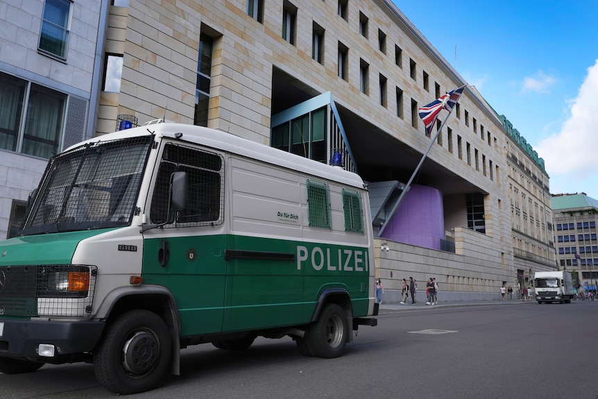 a police car in front of a big embassy building