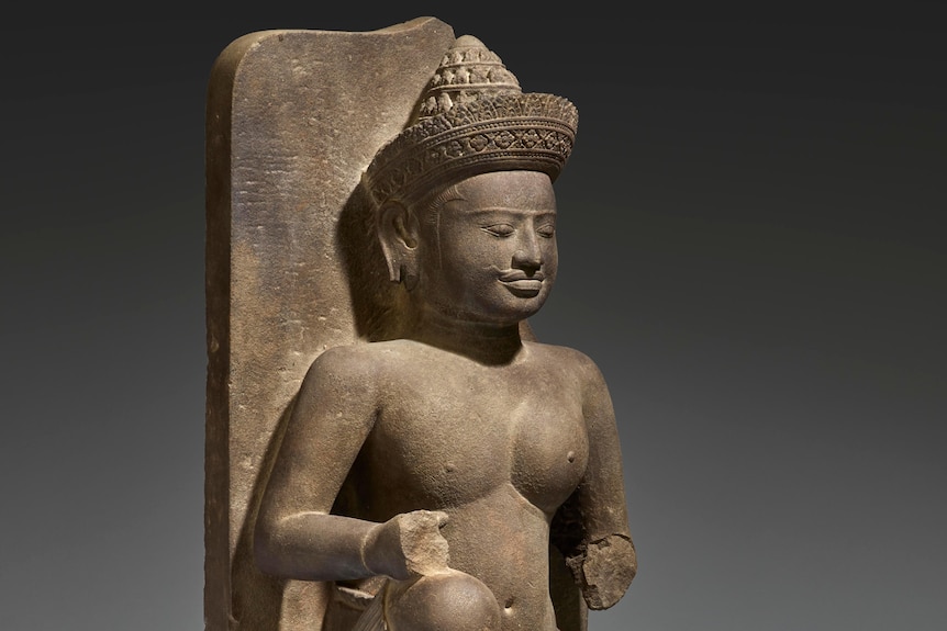 A stone statue of a seated figure. 