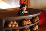 An ornament showing Kiki standing at the bakery counter.