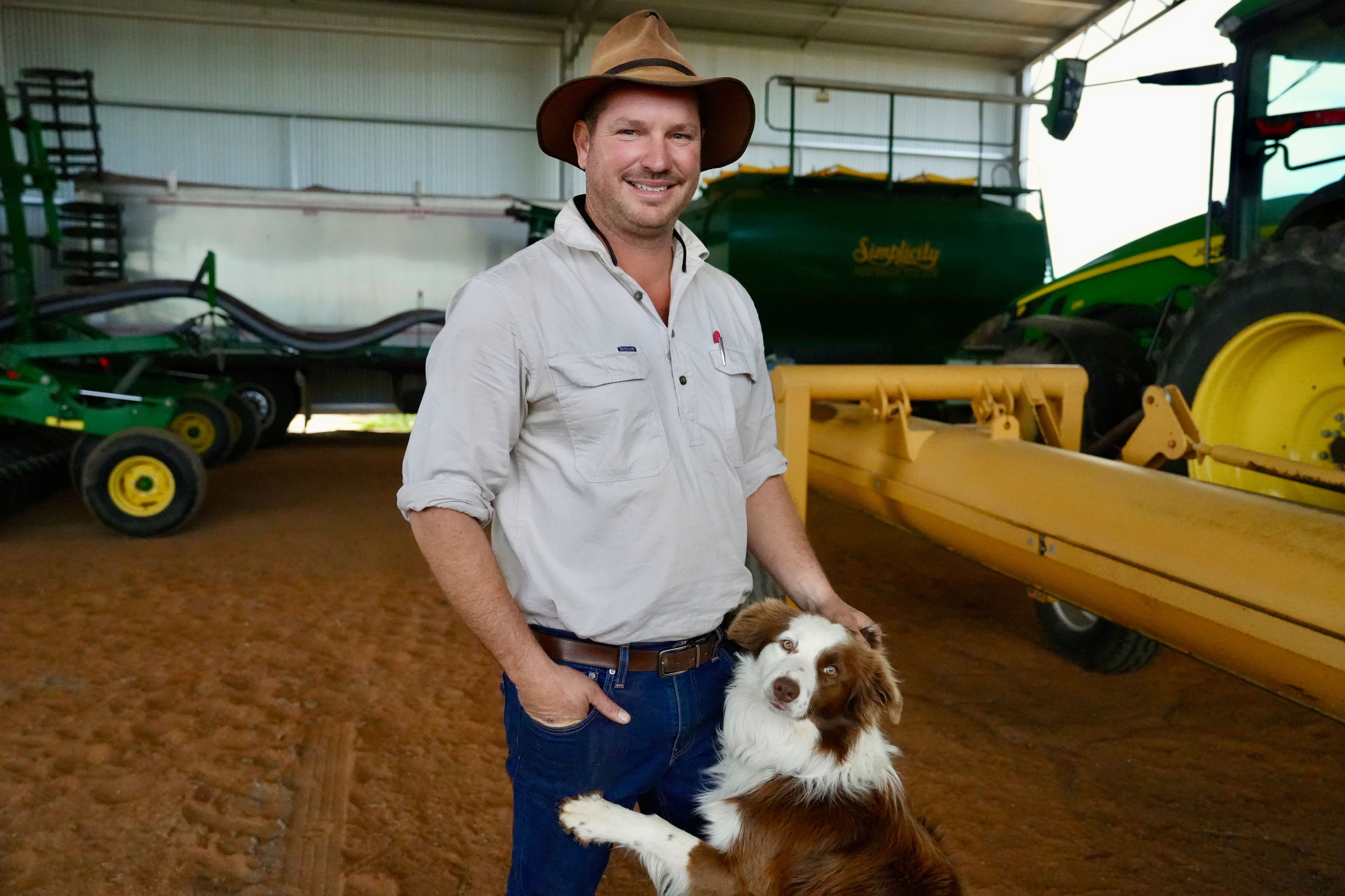 A man with a hat in front of machinery