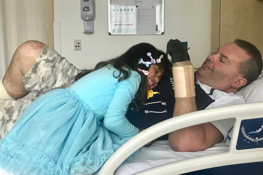Jayda hugs Buddy in his hospital bed.