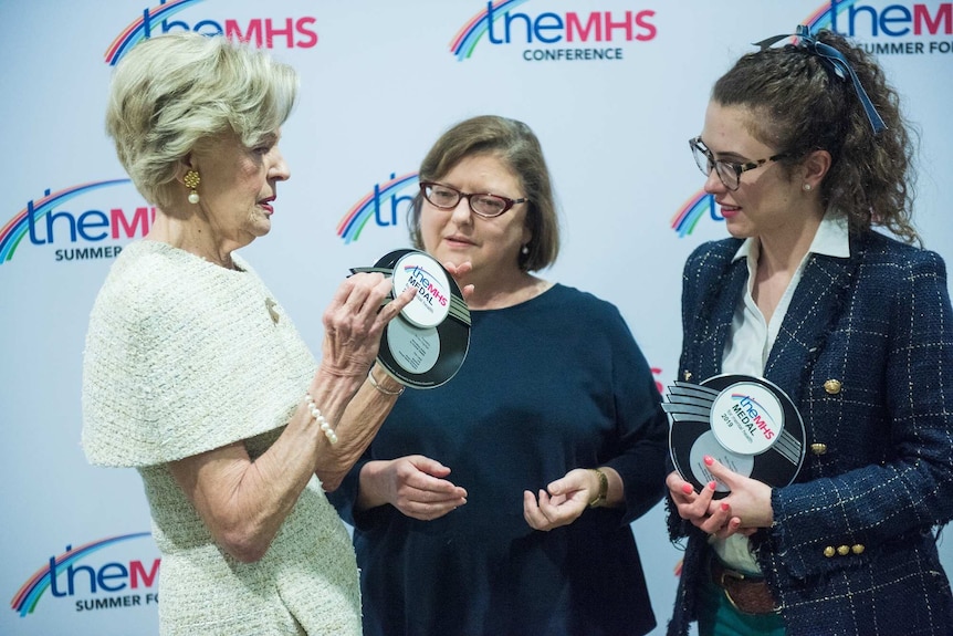 Three women with two trophies