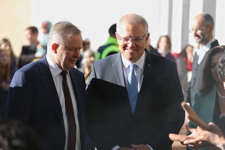 Anthony Albanese and Scott Morrison having their faces painted by Aboriginal elders outside Parliament House