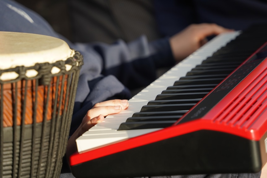 A young boy's hands on an electric keyboard