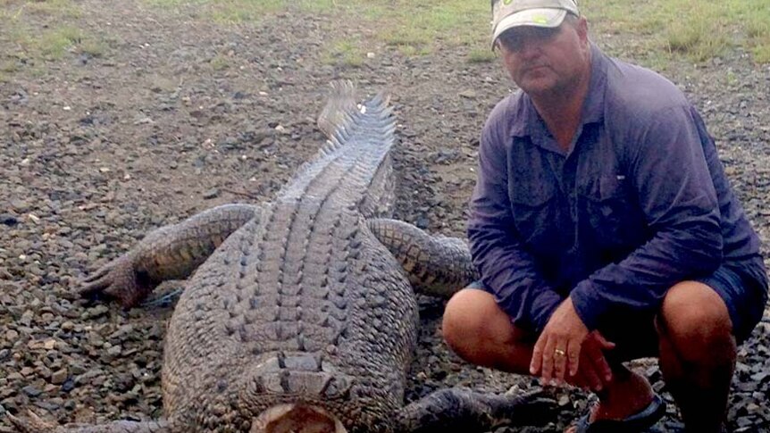 Cairns fisherman Jim Millar poses next to a headless three-metre crocodile
