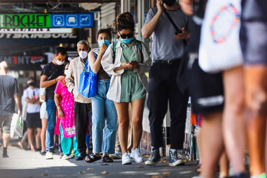 A line of people wearing masks