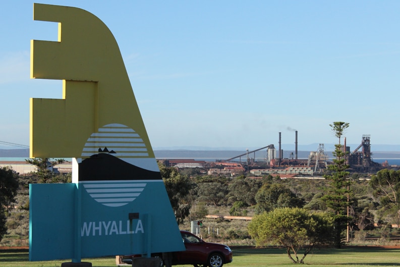 A sign noting the entry to Whyalla with Arrium's steel operation in the background.