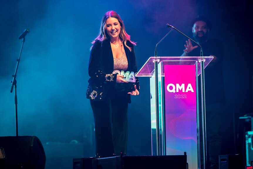 An image of Jem Cassar-Daley on stage at QMA behind lectern