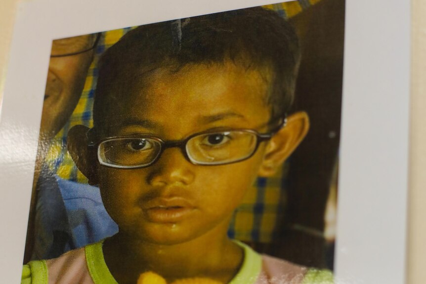 A photo of a child wearing glasses.