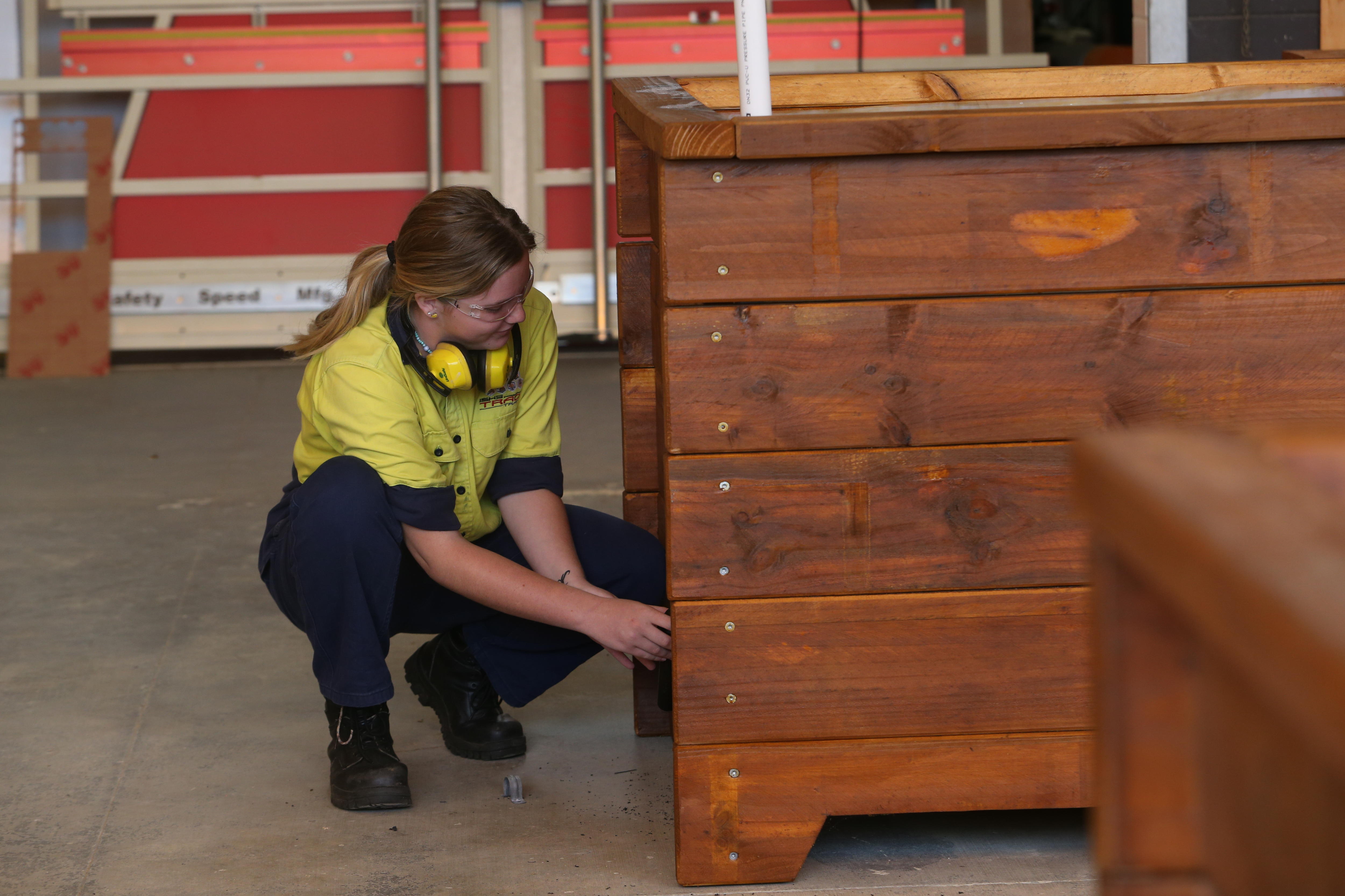 Girl builds planter box.