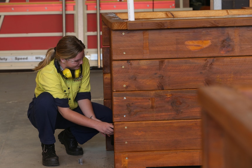 Girl builds planter box.