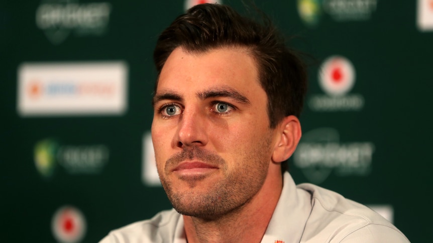 An Australian male cricketer looks on at a media conference.