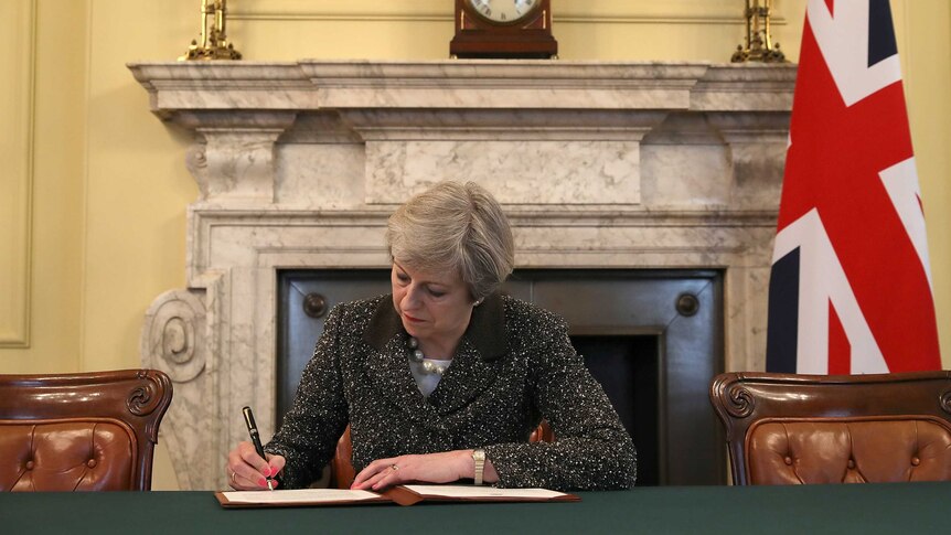 Theresa May in the cabinet office signs the official letter to trigger Brexit.