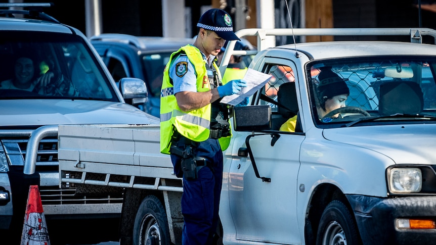 A police officer checking a driver's permit at the border.