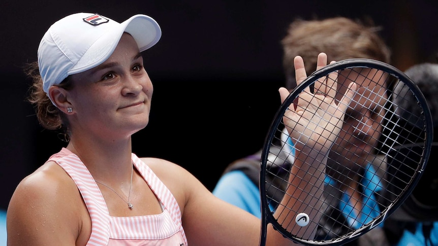 Ashleigh Barty claps with her racquet as she smiles and acknowledges the crowd at the Australian Open.