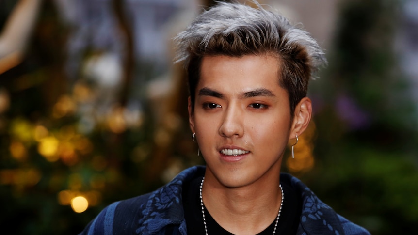 Kris Wu in a navy jacket and chain around his neck, with silver tipped hair