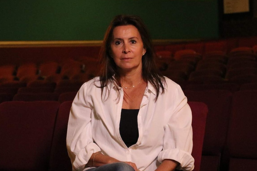 Tania Zimmerman sitting in a darkened theatre.