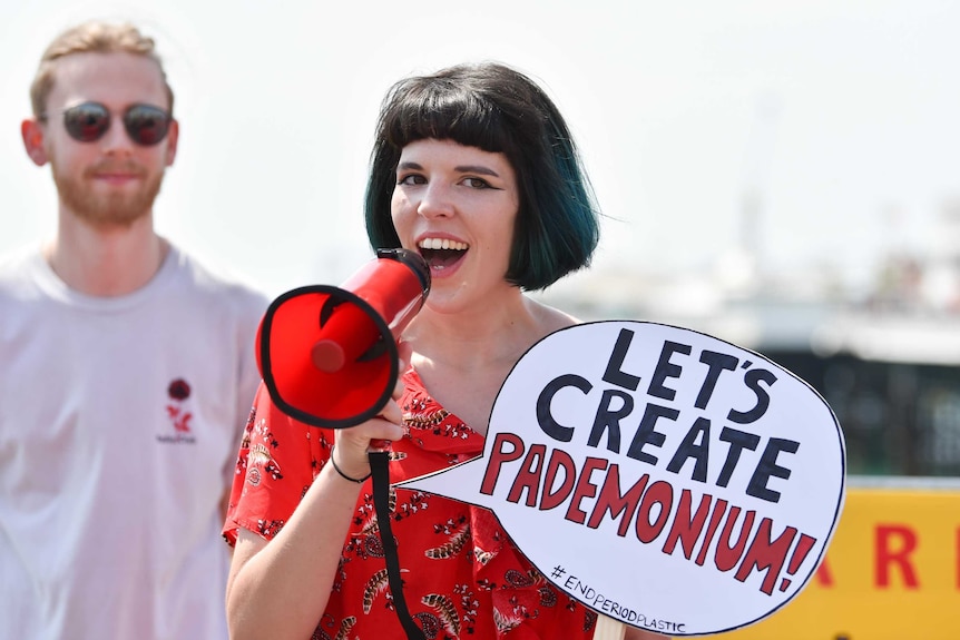 Ella Daish speaks on megaphone at a campaign for plastic free period products.