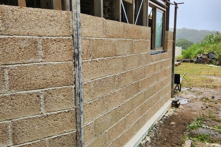 A house frame half filled with hemp bricks.