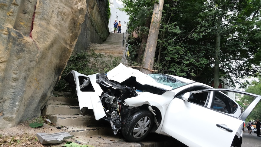 A smashed car at the bottom of a steep set of stairs