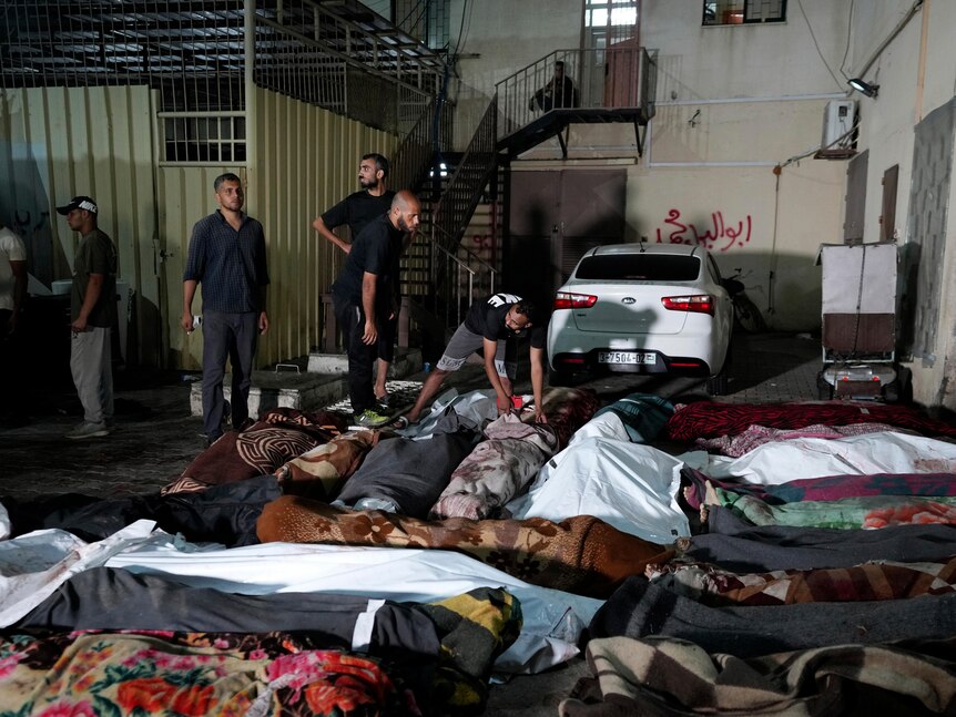 Palestinians check the bodies of their relatives killed outside al-Aqsa Martyras hospital 