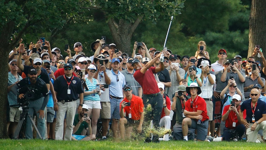Tiger Woods plays a show with a huge number of spectators behind him.