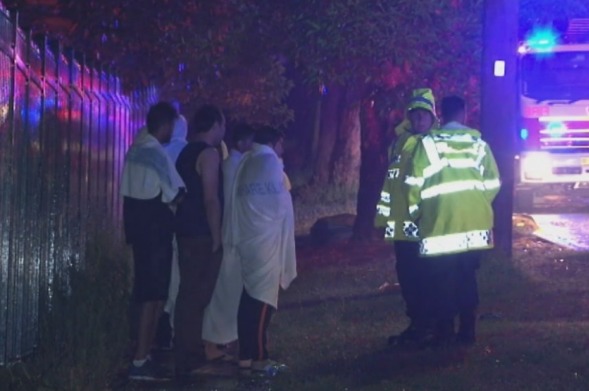 A group of young men talk with police on Florrie Street.